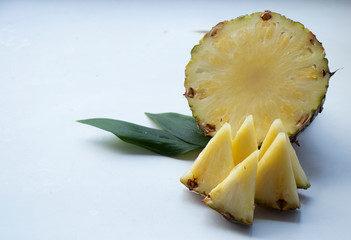 Sliced Pineapple on a turquoise background. Juicy fruit - summer mood with bright colors. On a wooden board and white background. Yummy.