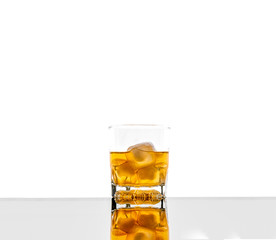 Glass with alcoholic drink with ice, on the rocks, whisky, rum, cognac, brandy, scottish, white background