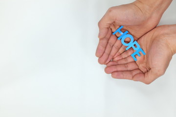 Hands holding hope word cutout in white background. Charity and give hope concept. Top view