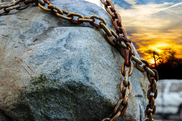 Cobblestone bound by an iron, rusty chain at sunset