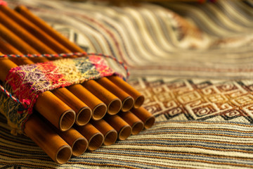 Close up view of Peruvian pan flute, on a coloured poncho. Concept of traditional Andean music.