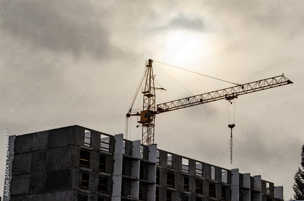 Wall mural overhead tower crane in cloudy weather