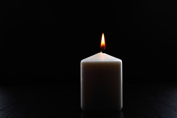 burning candle on a black background