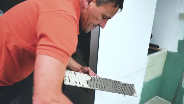  Fliesenleger bei der Arbeit, Renovierung eines Badezimmers 4k Video in zeitlupe