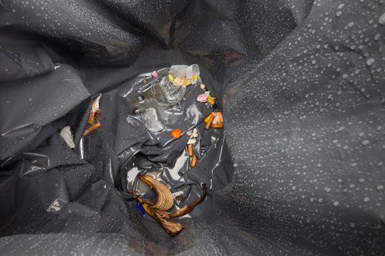 Inside view of waste bin with garbage and raindrops