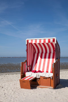 Germany, Lower Saxony, Dornum, Nessmersiel, red and white hooded beach chair
