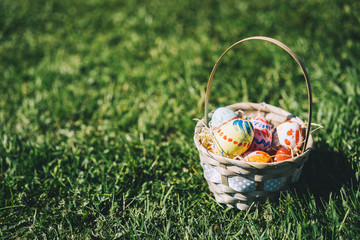 Painted easter eggs in wicker basket.