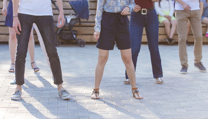 Social dance and flashmob concept - Fun and dance with in the summer on a city street. Close-up of dancers feet.