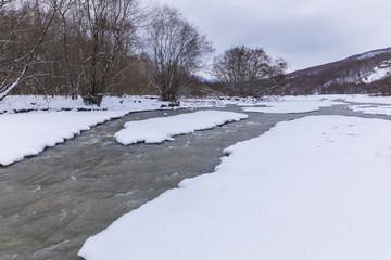 River passing through a mountain gorge in winter