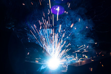 The process of welding metal in the dark with the formation of a large amount of smoke and sparks.