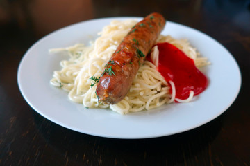 fried sausage with spaghetti and tomato ketchup on a plate