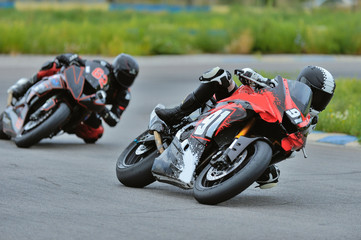 Motorcycle practice leaning into a fast corner on track