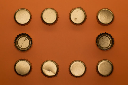 frame of bottle caps on orange background