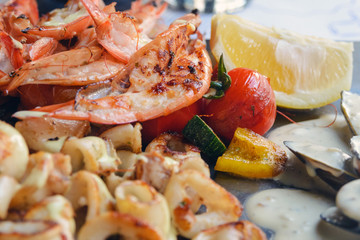 Fried seafood platter. Shrimp, squid, fish and vegetables in spicy sauce. Lunch at an old fish restaurant on the island of Cyprus. Gastronomic journey.