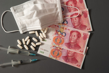 Chinese paper currency, syringe, medicine and face mask 