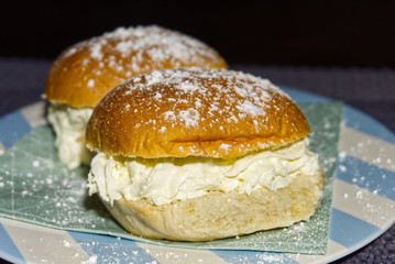 Delicious cream filled buns on a blue plate with white stripes