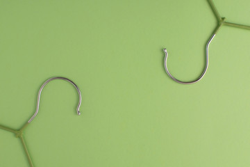 Flat lay with cloth hangers at green pastel background. Monochrom natural colours.