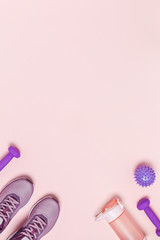 Sports equipment and shoes for women's training. Pink background, vertical picture.