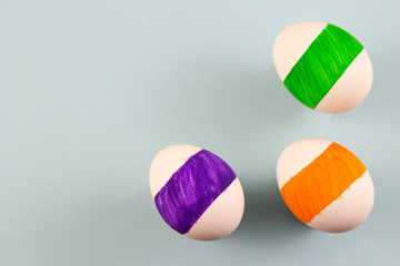 three colored eggs on a blue background. copyspace for text