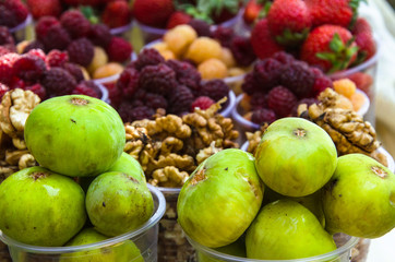 Ripe fruits in glasses for street sale. Jujube, Red and white raspberries, figs, nuts. Travel and adventure.