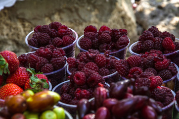 Ripe fruits in glasses for street sale. Jujube, Red and white raspberries, figs, nuts. Travel and adventure.
