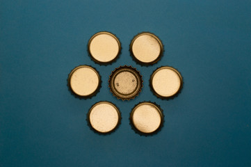 seven bottle caps on blue background