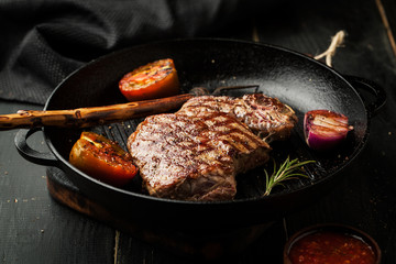 Grilled beef steak in a frying pan with vegetables