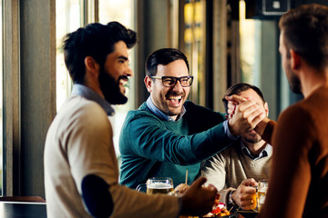 Group of friends enjoying in beer pub