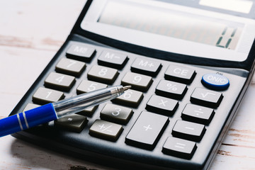 Accounting, financial concept, flat lay, calculator and pen on wooden table