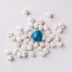 Minimalistic Easter background, one blue and white small eggs on a clean background