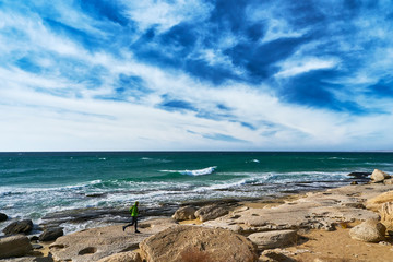 Man athlete runs along the seashore on a sunny day. Trail Running. Mangystau Peninsula. Kazakhstan