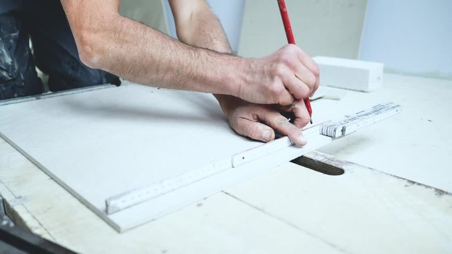 Handwerker schneidet grosse fliesen mit Fliesenschneider in einem neubau haus 4k Video in zeitlupe