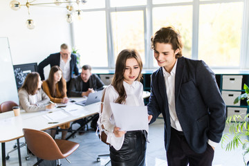 Business people communicating in front of office building and trying to sign the contract between two companies in front of meeting table