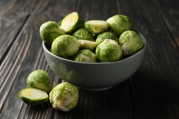 Bowl with brussels sprout on wooden background, close up