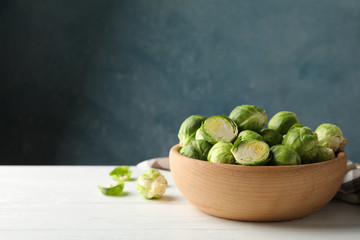 Bowl with brussels sprout on wooden background, space for text