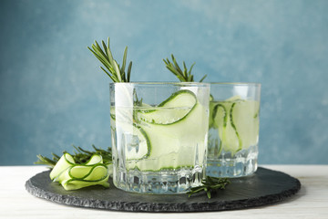 Tray with glasses of cucumber water on wooden table, close up