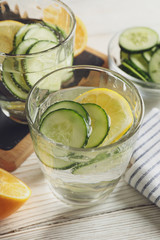 Composition with glasses of cucumber water on wooden background, close up