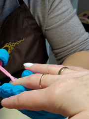 master covers the client's nails with gel Polish. close up.
