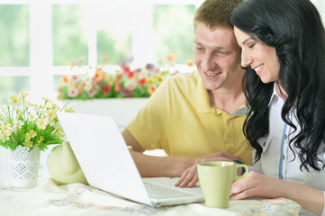Portrait of happy young couple with laptop