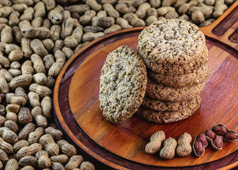 Homemade cookies tied in a bow, homemade biscuit with organic peanuts. Vegan biscuits on rustic wooden background. Healthy food and dessert concept.
