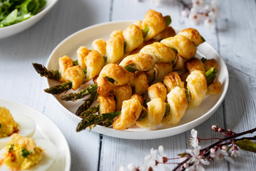 Aspargus wrapped in puff pastry on the white plate