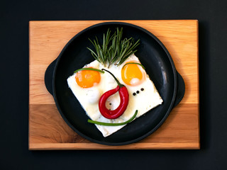Fried eggs with onions and pepper on a pan