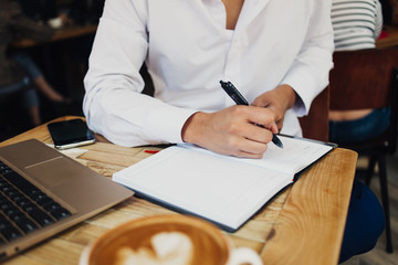 Crop man in white shirt working in cafe