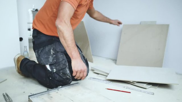 Handwerker schneidet grosse fliesen mit Fliesenschneider in einem neubau haus 4k Video in zeitlupe