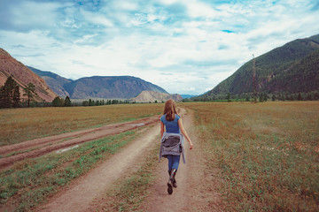 Obraz premium the girl stands with her back against the mountains