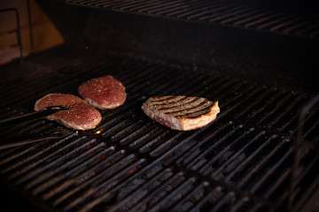 Delicious grilled meat with vegetable over the coals on a barbecue.Preparing hamburgers on a grill. Tasty Beef steaks on the grill. juicy and appetizing steak. Selective focus.
