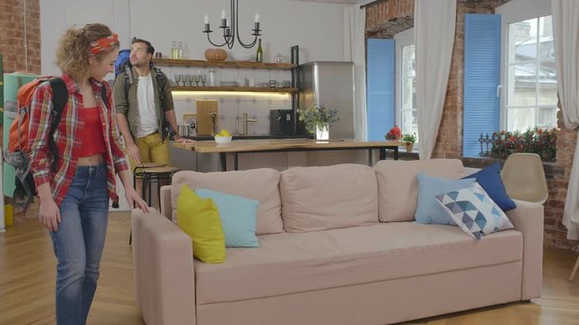 Young couple travelers with backpacks in rented apartment during vacation