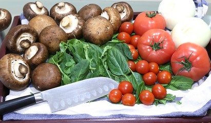 Still life from products: mushrooms, tomatoes small and large, onions view from above