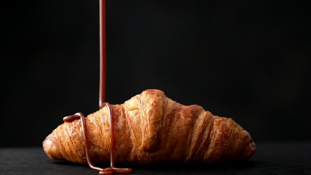 freshly baked croissant with chocolate sauce, slow motion
