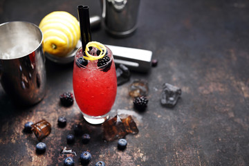 Alcoholic drink with blueberries and blackberries.